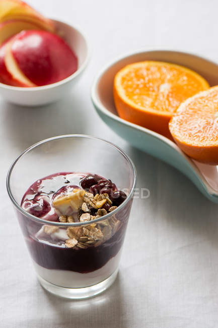 Breakfast table with yoghurt and oranges with apples — Stock Photo