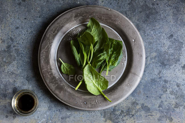 Свежий шпинат на деревенской бетонной посуде — стоковое фото