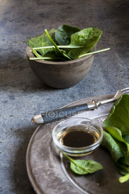Spinaci freschi su stoviglie in cemento rustico — Foto stock