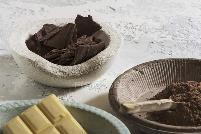 Close up bowls with dark and white chocolate on table — Stock Photo