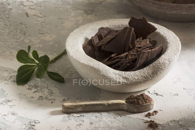 Still life of stone bowl with dark chocolate — Stock Photo