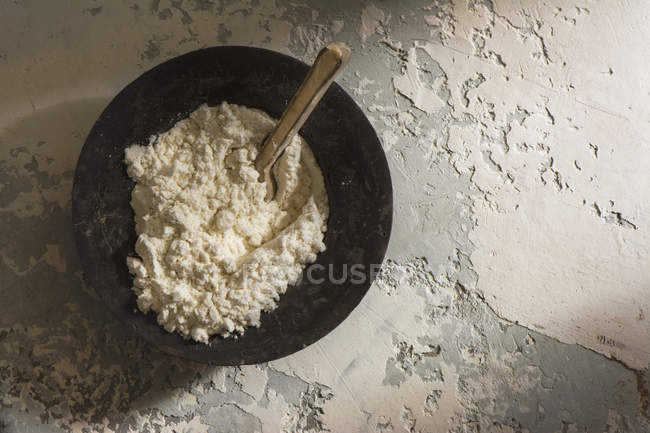 Directly above view of rural bowl with flour and wooden spoon — Stock Photo