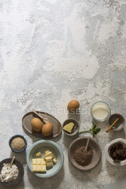 Bowls with baking ingredients on stone table — Stock Photo