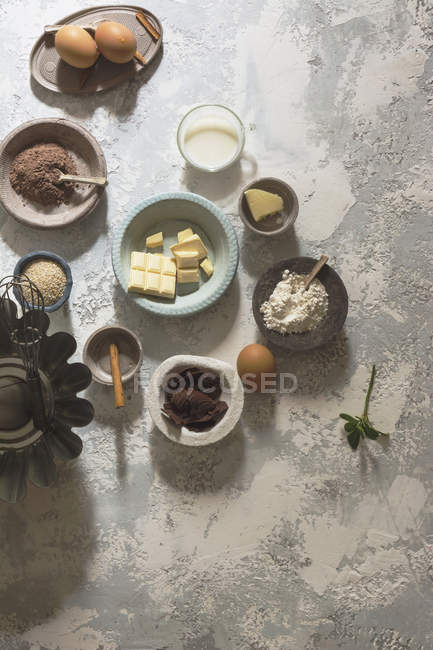 Arrangement of bowls with baking ingredients on stone table — Stock Photo