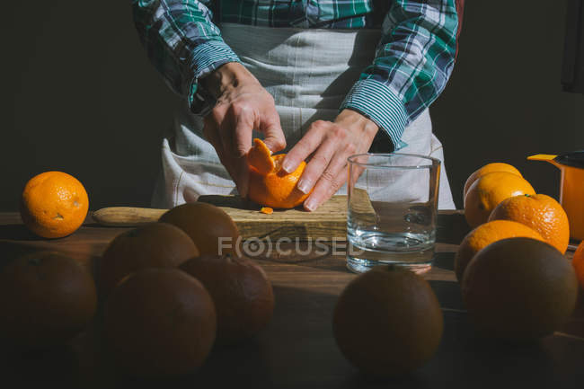 Woman hand peeling ripe sweet tangerine — Stock Photo