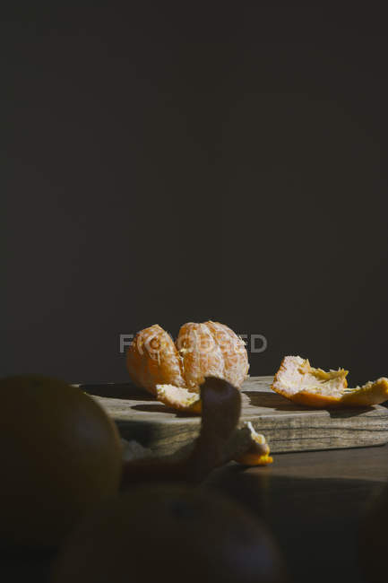 Mandarine pelée sur planche de bois — Photo de stock