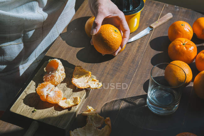 Женщина очищает спелый сладкий мандарин — стоковое фото