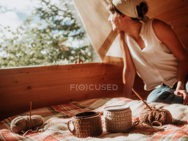 Femme sur maison en bois profitant du soleil — Photo de stock
