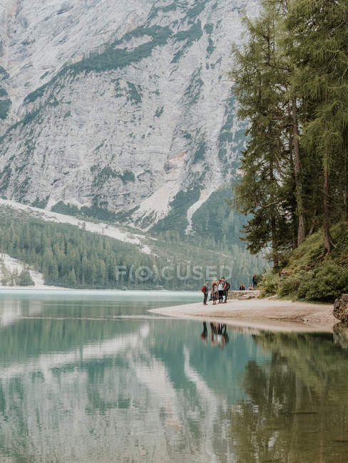 Grupo de personas en el lago en las montañas - foto de stock