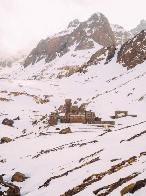 Maison dans neiges de montagnes — Photo de stock