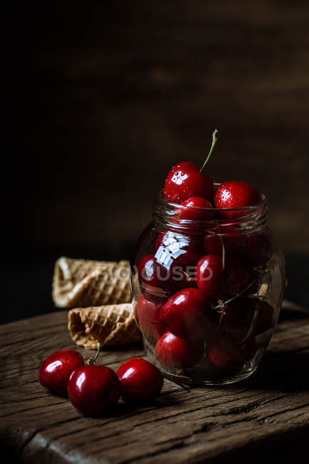 Cherries jar and waffle cones — Stock Photo