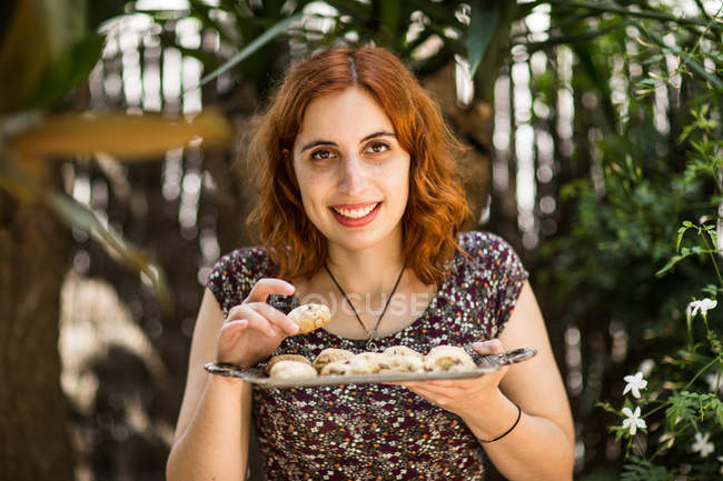 Улыбающаяся женщина с домашним печеньем — стоковое фото