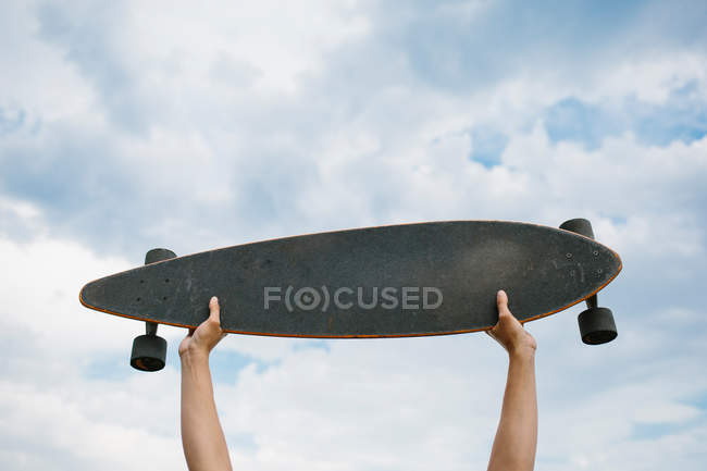 Mani che tengono lo skateboard — Foto stock