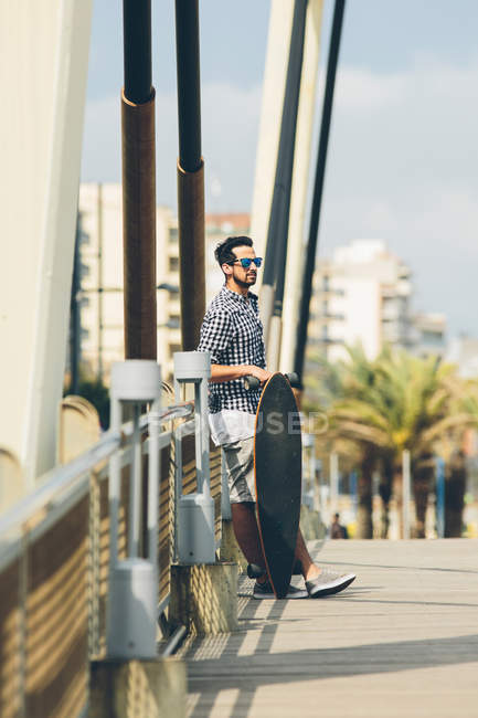 Mann steht mit Skateboard — Stockfoto