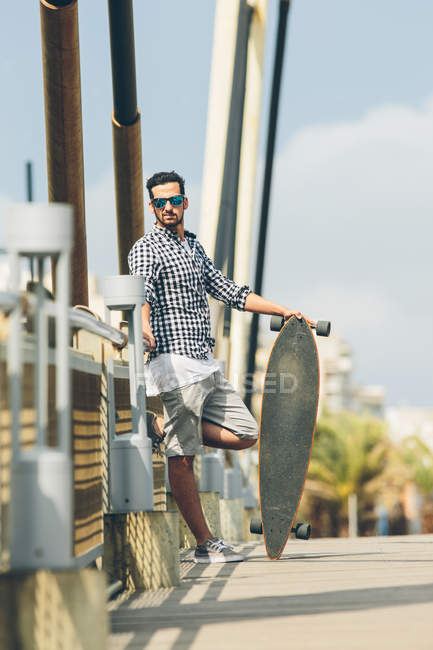 Homem de pé com skate — Fotografia de Stock