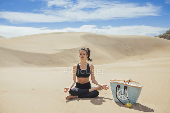 Mujer practicando yoga en el desierto - foto de stock