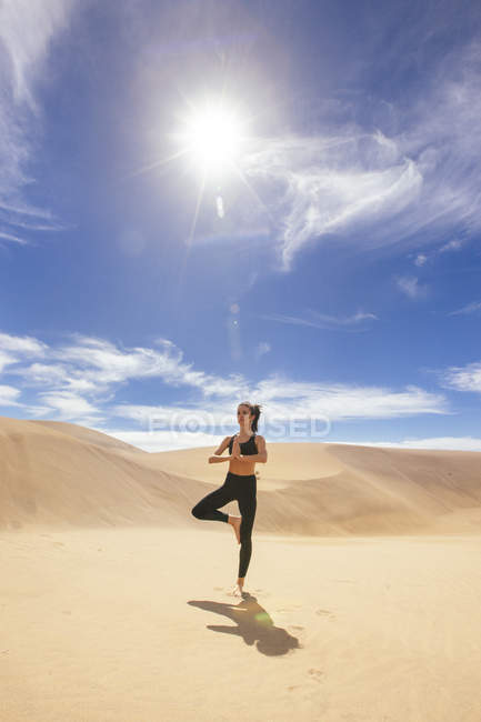 Женщина растягивает ноги в пустыне — стоковое фото