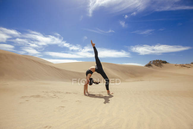 Женщина растягивает тело в пустыне — стоковое фото