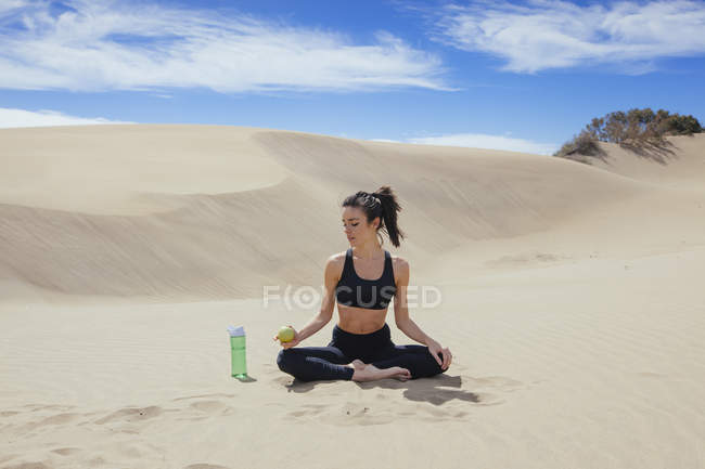 Жінка розтягує тіло в пустелі — стокове фото