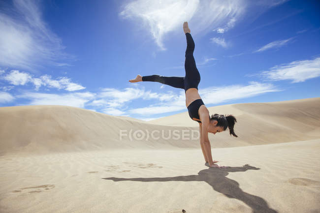 Женщина в ладони на песке — стоковое фото