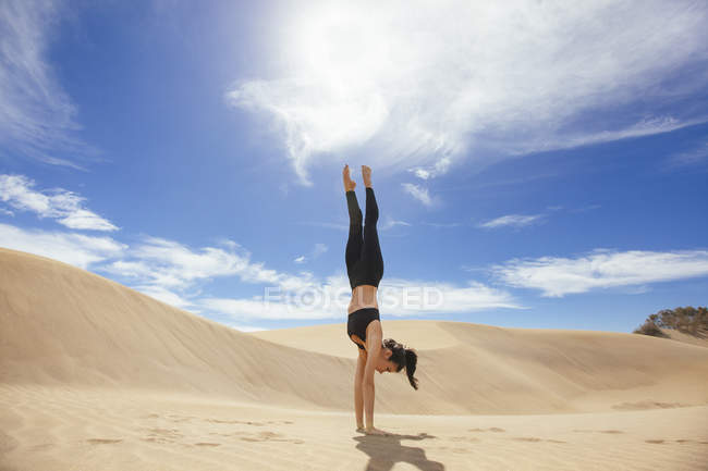 Woman practicing yoga in sands — Stock Photo