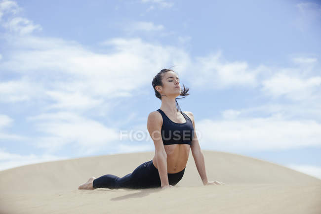 Mujer pacífica en pose de yoga - foto de stock