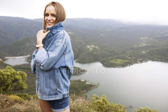 Молода жінка посміхається на скелі — стокове фото