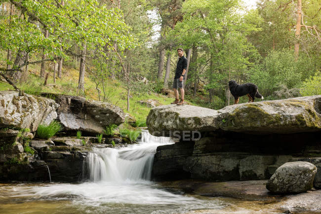 Young man at waterfall — Stock Photo