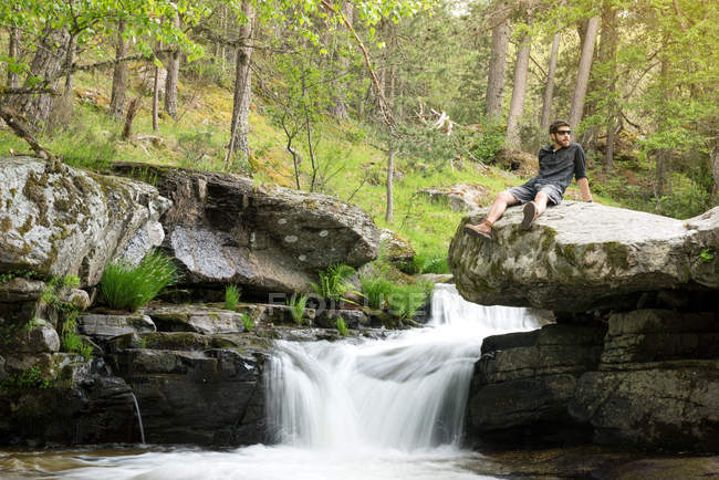 Young man at waterfall — Stock Photo