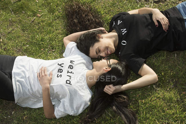 Couple lesbienne couché sur la pelouse — Photo de stock