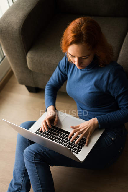 Frau surft am Laptop auf dem Boden — Stockfoto