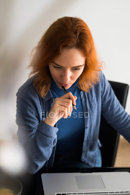 Femme pensant à un ordinateur portable — Photo de stock