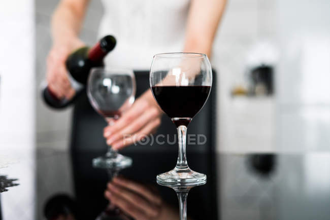 Femme versant du vin rouge — Photo de stock