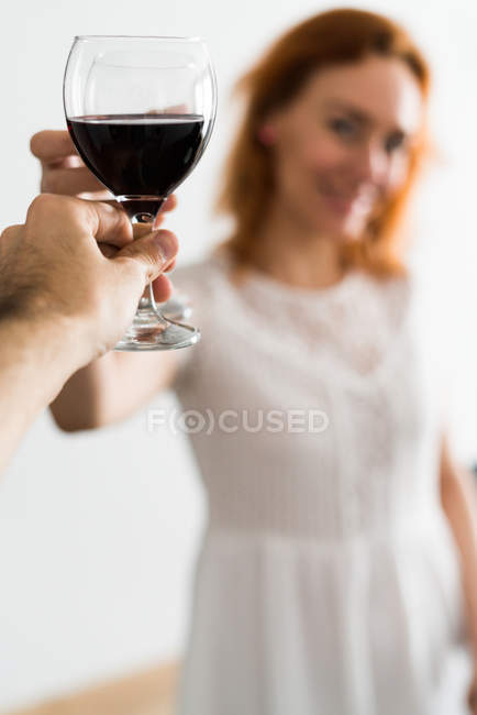 Person clanging glasses with woman — Stock Photo