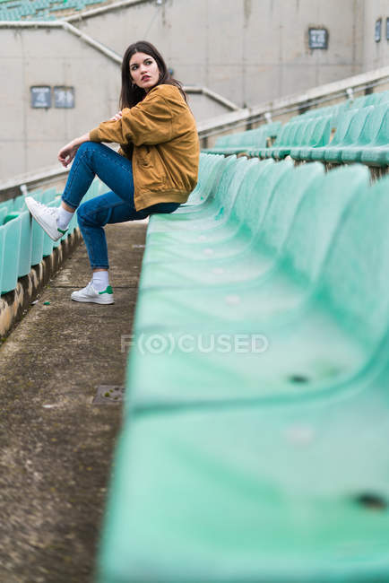 Young cute girl in abandoned stadium — Stock Photo