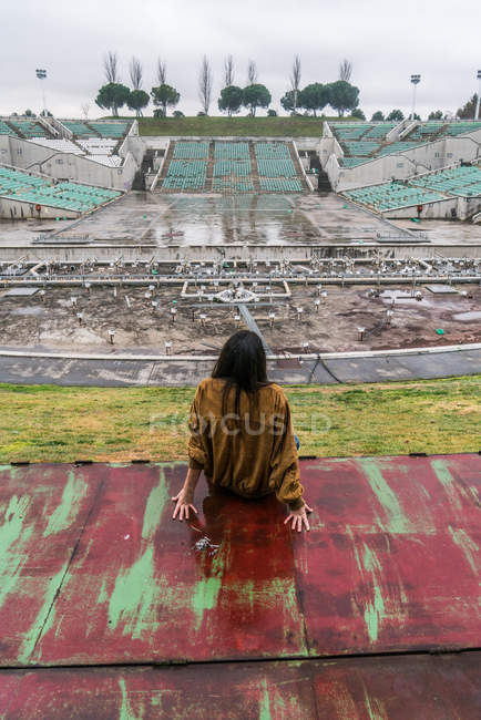 Молодая милая девушка на заброшенном стадионе — стоковое фото