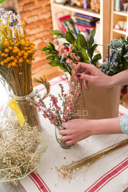 Crop persona che compone fiori in borsa — Foto stock
