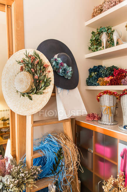 Beautiful female hats on flower shop — Stock Photo