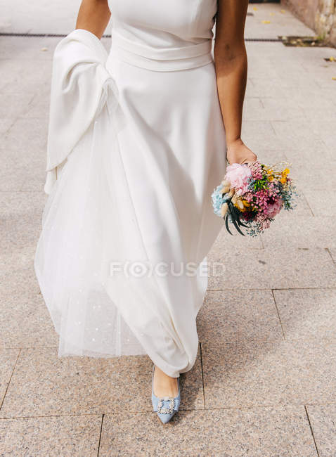 Crop femme en robe blanche avec bouquet — Photo de stock