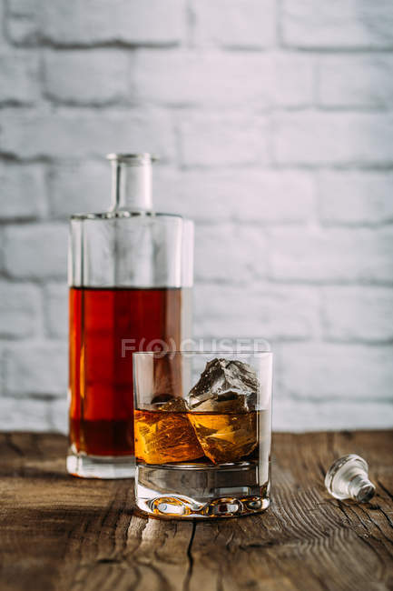 Vaso de whisky sobre mesa de madera - foto de stock