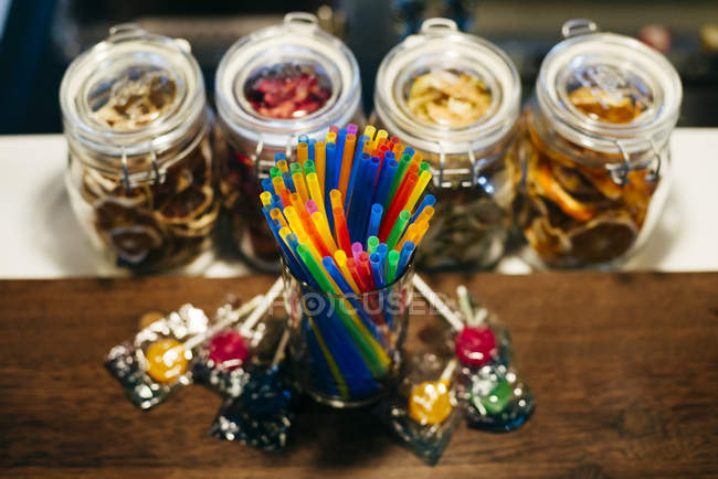 Straws and candies on counter — Stock Photo