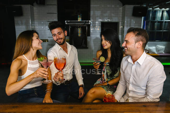 Друзья пьют коктейли в баре — стоковое фото