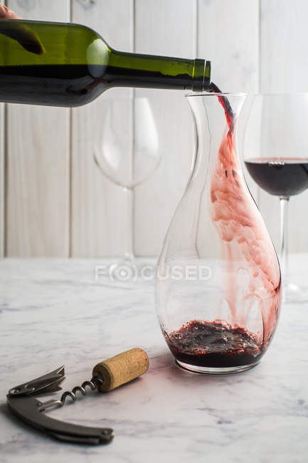 Versare il vino rosso dalla bottiglia — Foto stock