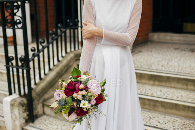 Frau mit Blumen im weißen Kleid — Stockfoto