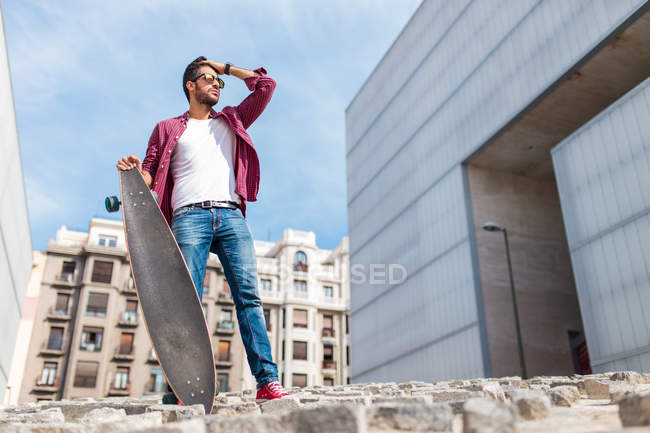 Homme élégant posant avec longboard — Photo de stock