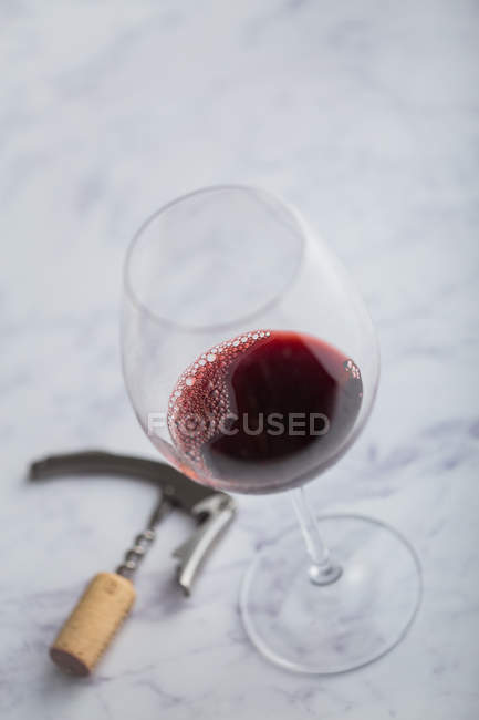 Vinho tinto e vidro na mesa de mármore — Fotografia de Stock