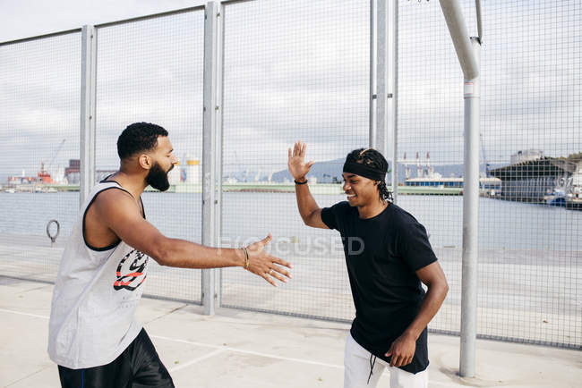 Спортсмены приветствуют друг друга на спортивной площадке — стоковое фото
