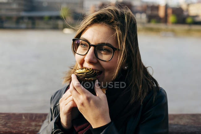Donna che morde cupcake — Foto stock