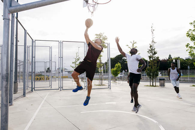 Hommes jouant au basket — Photo de stock