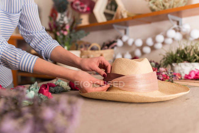 Crop woman decorating hat — Stock Photo